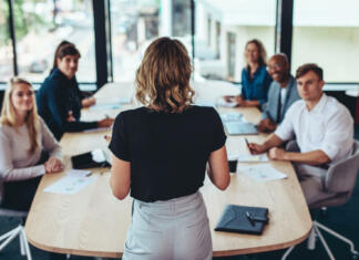 Predavanje PR-ovke Kaly Kolonič na FDV-ju Rear view of a businesswoman addressing a meeting in office. Female manager having a meeting with her team in office boardroom.
