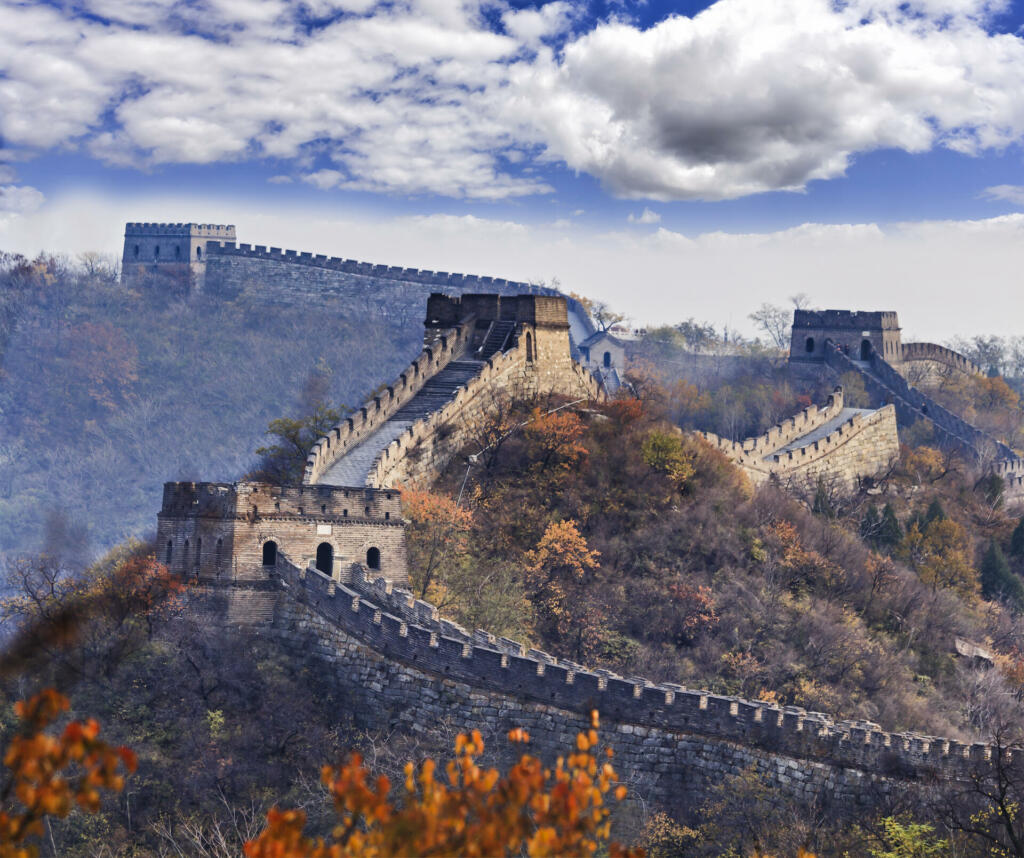 Several towers of Great Wall of Chine near Mutianyu north from Beijing high in mountains at autumn with yellow trees