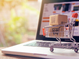 Shopping online concept - Parcel or Paper cartons with a shopping cart logo in a trolley on a laptop keyboard. Shopping service on The online web. offers home delivery.