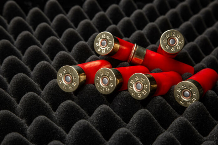 Shotgun shells on foam rubber. Ammunition for 12 gauge smoothbore weapons. Hunting ammunition. Dark background.