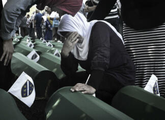 Srebrenica 25 let po genocidu Since 2005, in July, people from all over the world have been arriving in Bosnia and Herzegovina to attend the funeral ceremony held for the victims of the genocide at the Potočari Memorial.Four hundred Dutch UN soldiers had the task of defending the territory of Srebrenica, declared an area under international protection. But it didn't happen. When Serbian troops on 11 July 1995 occupied Srebrenica under the command of General Mladic, UN soldiers retreated here to their base in Potocari and did not defend the city. The UN commands did not make the fighters intervene to stop the Serbs thus allowing the massacre.The coffins are covered with green canvas, inside there are the few remains of the killed person. A tag with a number remembers its name. Family members and relatives look for their loved one's coffin. They caress her, someone sits next to them and stays there for hours.