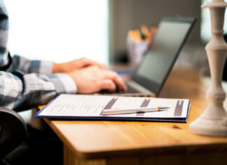 Reminder: kaj vse moram urediti pred začetkom faksa? Survey form, customer satisfaction feedback poll, resume for job application or for college. Man writing with laptop. Home or car insurance contract. Paper sheet and pen on desk.