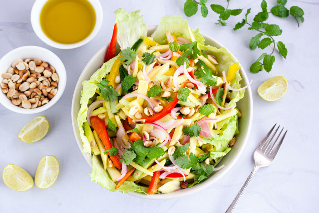 Thai Raw Mango Salad on the Table Directly from Above Photo. Thai Mango Salad with Roasted Peanuts.