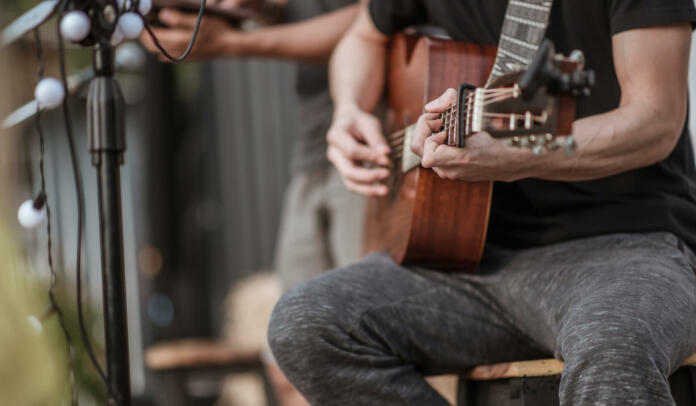 The musicians are checking the sound of the guitar and trying to play the guitar before the event starts. Concert,mini concert and music festivals.