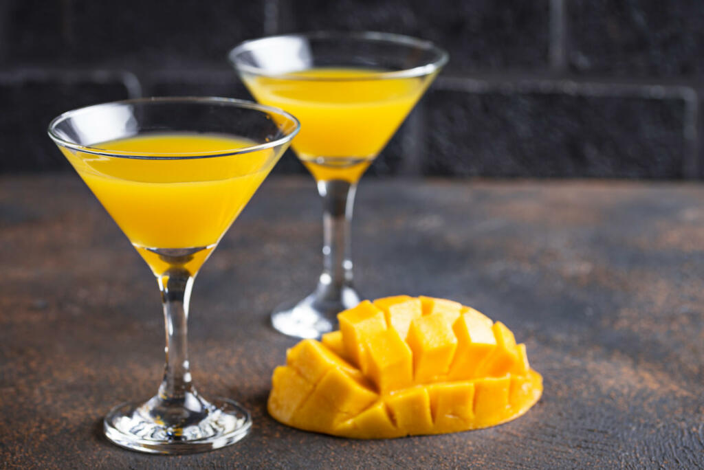 Tropical fruit cocktail with mango on dark background