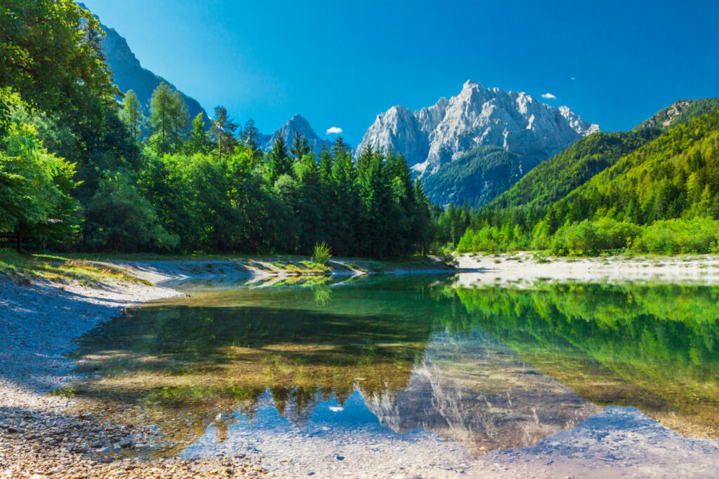 Valley with the lake in the Triglav National Park. The water surface reflects the surrounding mountains in Julian Alps , Slovenia