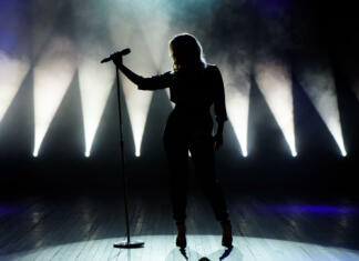 RBD se vrača na koncertne odre! Vocalist singing to microphone. Singer in silhouette.