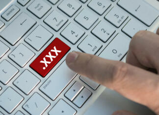 Arnes klical na Pornhub, da bi jih vprašal, kako jim delujejo strežniki XXX button on keyboard. A male finger presses a color button on a gray silver keyboard a modern laptop. Button with inscription close up. Watching pornography on a computer. Internet Masturbation.