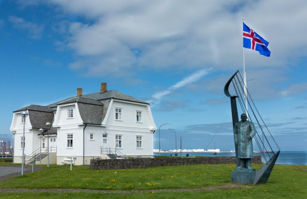 Zastava Islandije na zelenici pri stavbi na Islandiji