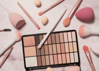 Kako postaneš makeup artist? Intervju z artistko Kim Mikuš A nude eyeshadow palette and makeup artist's tools on a marble vanity. Brushes for powder, blush, eyebrows, shadows and sponges for concealer and foundation.