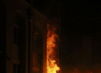 Požar največjega podatkovnega centra v Evropi povzročil padec več spletnih strani A shed and building burning at night.