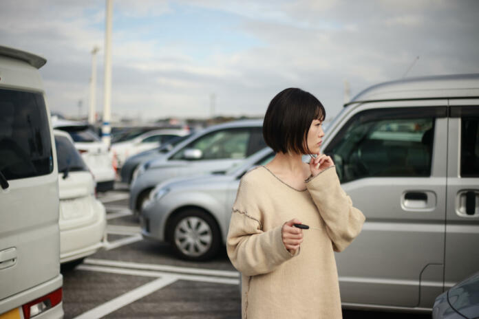 A woman looking for a car in the parking lot