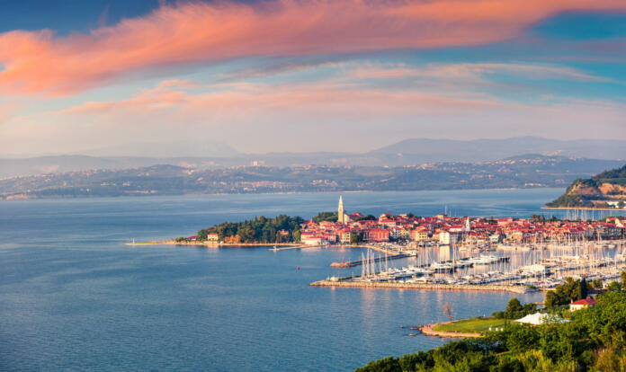 Aerial view of old fishing town Izola. Impressive spring sunset in Slovenia, Europe. Beautiful seascape Adriatic Sea. Traveling concept background.