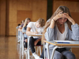 Anxious Teenage Student Sitting Examination In School Hall