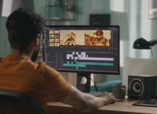 Poletje je čas za nakup računalnika Back view of male content creator using computer to edit cosmonaut video during remote work from home