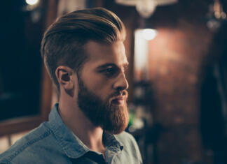 Slovenci nimamo sanjskega moškega Barbershop concept. Profile side portrait of attractive severe brutal red bearded young guy. He has a perfect hairstyle, modern stylish haircut