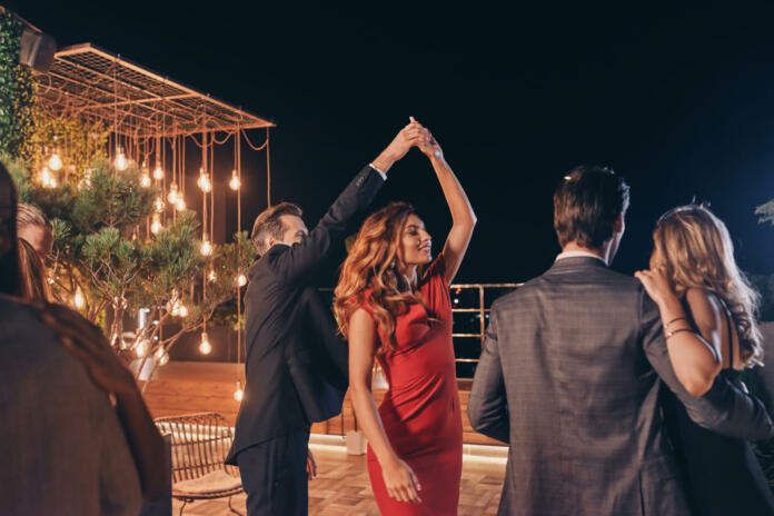 Beautiful young people dancing and smiling while spending time on luxury party