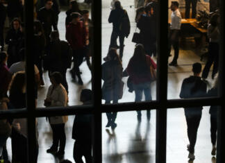 Načrtovanje kariere je za mlade vse pomembnejše Bucharest, Romania - Novemder 07, 2018: The silhouettes of students are seen through a window at a job fair in Bucharest. This image is for editorial use only.