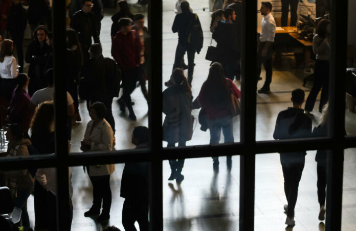 Bucharest, Romania - Novemder 07, 2018: The silhouettes of students are seen through a window at a job fair in Bucharest. This image is for editorial use only.