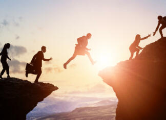 „Work hard, play harder.“ Challenge of business concept. Group of businesspeople climbing a mountain. Teamwork. Success.