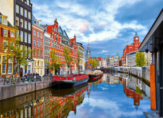 7 stvari, ki jih morate vedeti pred potovanjem po Evropi Channel in Amsterdam Netherlands houses river Amstel landmark old european city spring landscape.