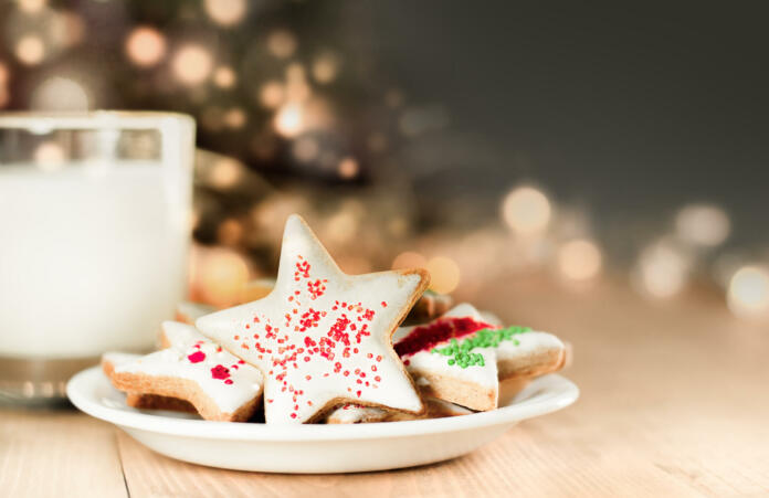 christmas cookies and milk for santa on a defocus christmas tree background