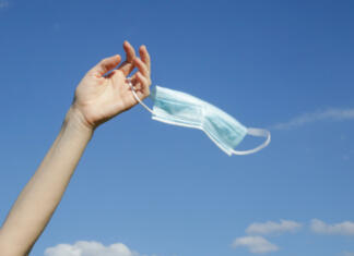 Država, ki ne ve, kaj je covid-19, bo kmalu dosegla precepljenost Coronavirus is finish. The end of quarantine and Corona Virus pandemic. Woman taking off and throw away medical protective mask. Enjoying life and fresh air after coronavirus pandemic.