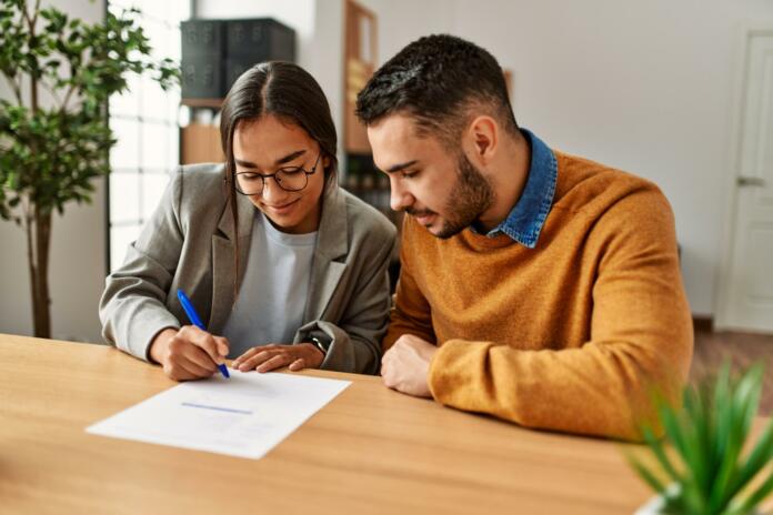 Couple smiling happy reading document at the office.