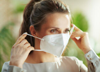 Koronavirus: miti in resnice covid-19 pandemic. middle aged woman in grey blouse wearing ffp2 mask.