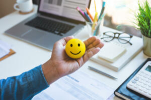 Emoticon ball on male hand on work table.happy life concepts.inspiration and motivation idea