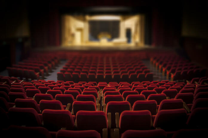Empty red armchairs of a theater ready for a show