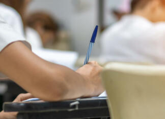 Napovedan odlog pisanja mature Exam with school students in class back view of the classroom of young people having stress doing examination admission test for university and college education background