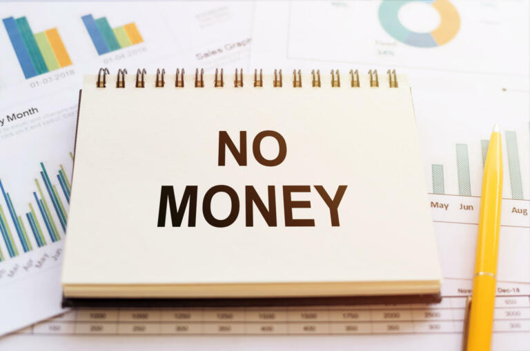 Financial graphs and charts and a note no money. The concept on the lack of free money among the population and the lack of ability to accumulate it