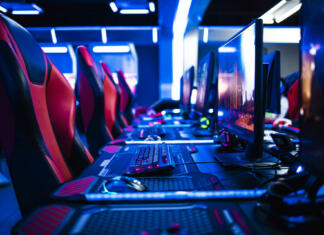 Kakšen računalnik rabim za gaming in prosumer? Game room interior with modern ambient lights and powerful super computers, consoles, keyboards for playing video games. Entertaining industry.