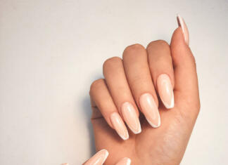 Nohti povedo, kako zdravi smo Gentle camouflage gel polish on long square nails with a French design. Hands with a professional manicure in a shirt. Trendy nail coating with French design.