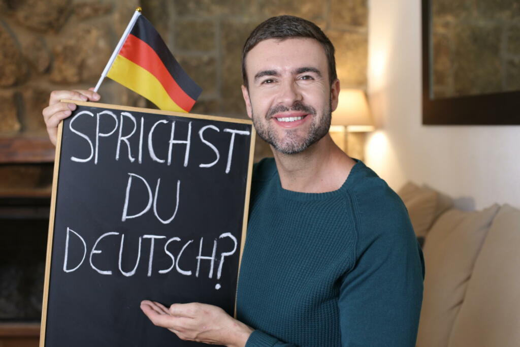German teacher holding blackboard and flag.