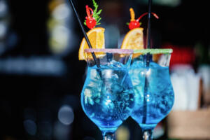 glass of alcoholic cocktail blue lagoon with ice