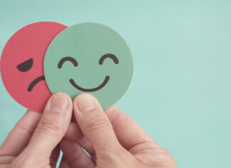 Tabu tema: duševno zdravje, 2. del Hands holding sad face hiding behind happy face, bipolar and depression, mental health, split personality, mood change,