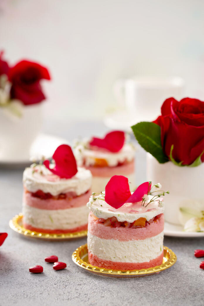 Light mousse cakes for Valentines Day garnished with rose petals