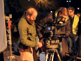 London, UK - March 30, 2012:  Film Crew On Location Night Shoot. DoP and assistant preparing to shoot using 4k camera.