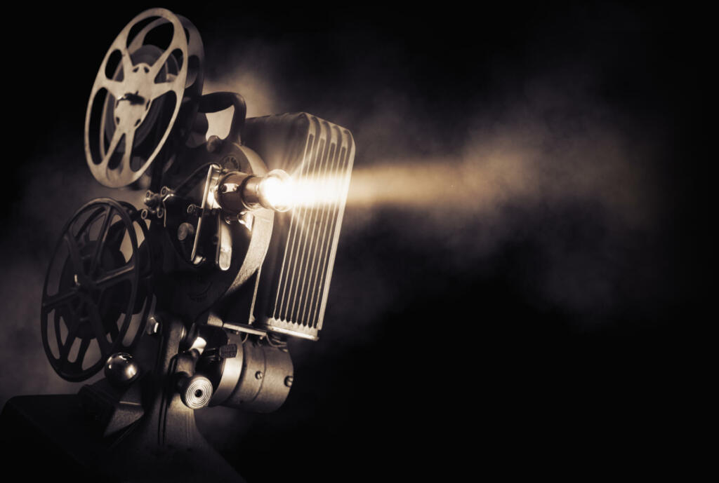 Movie projector on a dark background with light beam / high contrast image