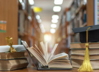Kako lahko prehajam med univerzami? Online education course, E-learning class and e-book digital technology concept with pc computer notebook open in blur school library or classroom background among old stacks of book, textbook