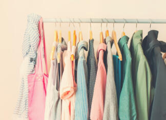 Prvi slovenski dan v rabljenih oblačilih Pastel Color Female Clothes in a Row on Open Hanger. Toned image