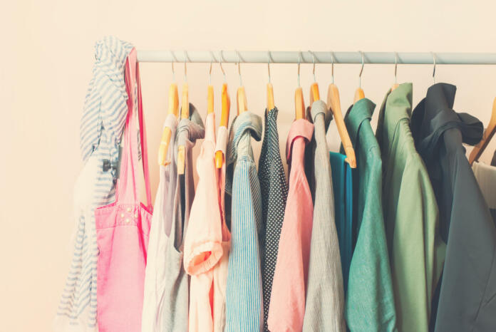 Pastel Color Female Clothes in a Row on Open Hanger. Toned image