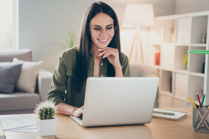 Portrait of charming successful cheerful focused girl working remotely creating finance it presentation report at home house flat indoor.