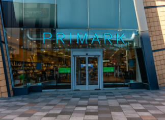 8 razlogov, zakaj je Primark tako poceni Primark, Drake Circus Shopping Centre, Plymouth, Devon, UK - November 22nd 2021: Exeter Street entrance. Newly opened Cineworld in the reflection.