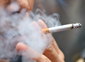 Cigareti Smoking a cigarette with smoke around and a blurred background