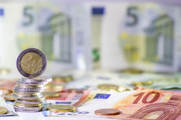 Stack of european coins and bank notes in the background show international finance with euro and europe, european trade and financial trade as well as saving, financial success and credit management