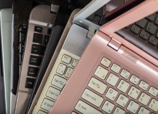 Kaj storiti s starim računalnikom? Stack of used laptops in different colors and models. Tha notebooks for repair and service.