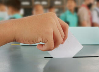 Koliko volilnih upravičencev ima tvoja občina? Students hands voting in the ballot box Voters on Election Day for the student council and the school board